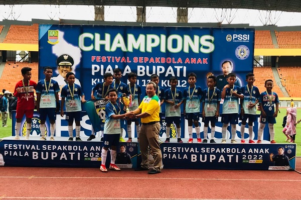 Ketua PSSI Kabupaten Bekasi Haji Hamun Sutisna Menyerahkan Piala Ke Tim Sepak Bola Usia 12 dari SSB Aqua Hair