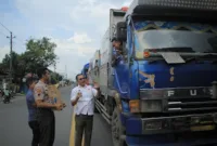 Kajari Rembang, Muhamad Fahrorozi SH MH (kemeja putih) membagikan air mineral kepada para sopir di tengah kemacetan