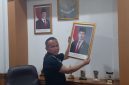 Teks Photo: Saat Rojab Asy'ari Menurunkan Foto Wakil Presiden Gibran Rakabuming Raka.