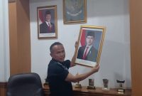 Teks Photo: Saat Rojab Asy'ari Menurunkan Foto Wakil Presiden Gibran Rakabuming Raka.