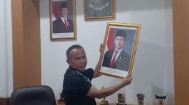Teks Photo: Saat Rojab Asy'ari Menurunkan Foto Wakil Presiden Gibran Rakabuming Raka.