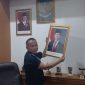 Teks Photo: Saat Rojab Asy'ari Menurunkan Foto Wakil Presiden Gibran Rakabuming Raka.